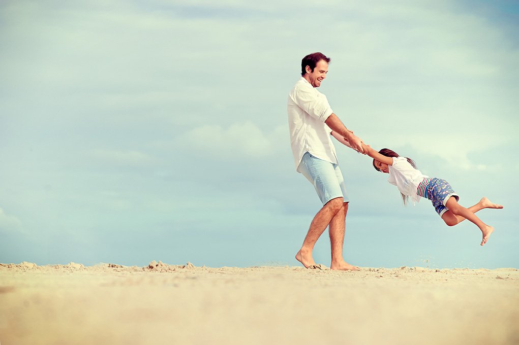 homme joue avec enfant sur la plage